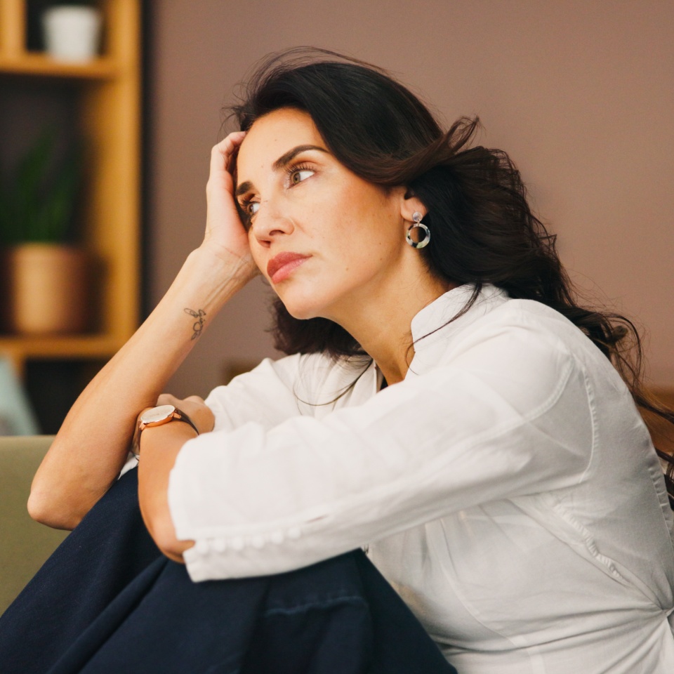 Thinking, sad and woman in home on sofa with anxiety for issue, depression and reflection in living room. Apartment, morning and thoughtful person with worry, overthinking and wondering in house.