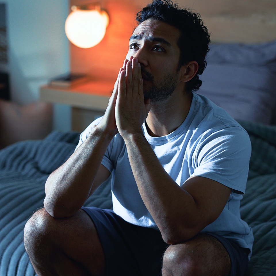 Night, stress and thoughtful man with anxiety, mental health and prayer for insomnia in bedroom. Late, contemplation and anxious person with depression, grief and praying for sleeplessness in house