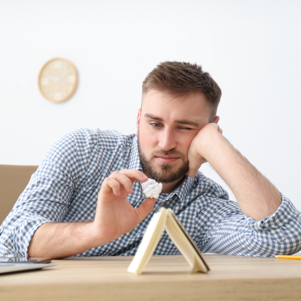Lazy young office employee procrastinating at workplace