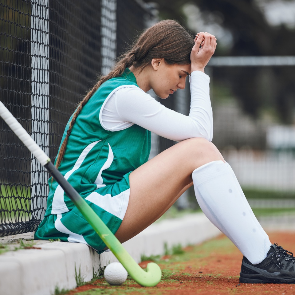 Player, headache and woman with burnout, hockey and anxiety with fitness, mistake and depression. Person, athlete and girl outdoor, migraine and stress with mental health, lose and sports with injury.